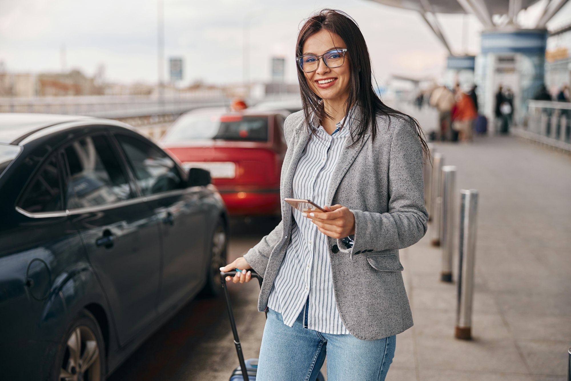 Happy caucasian woman traveller in airport terminal is taking a CEC Minicabs taxi