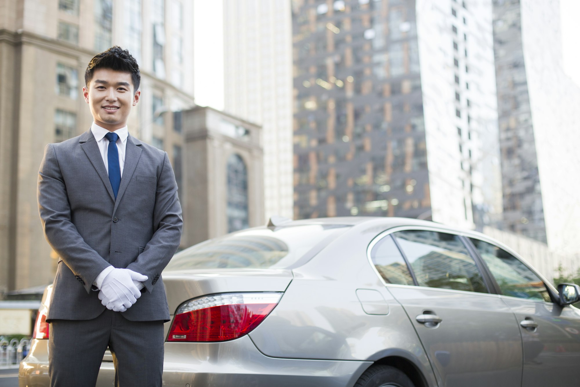 Portrait of CEC chauffeur standing next to the car