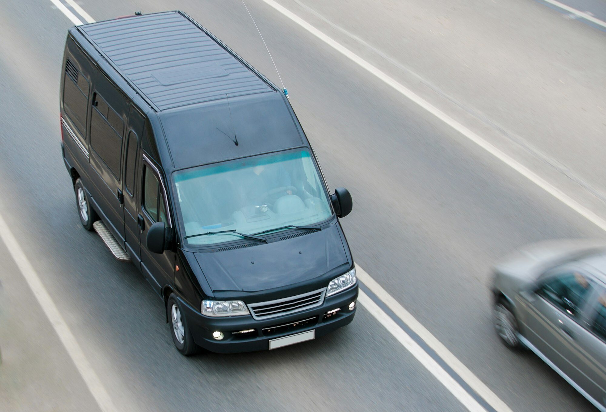 The black minibus goes on a suburban highway